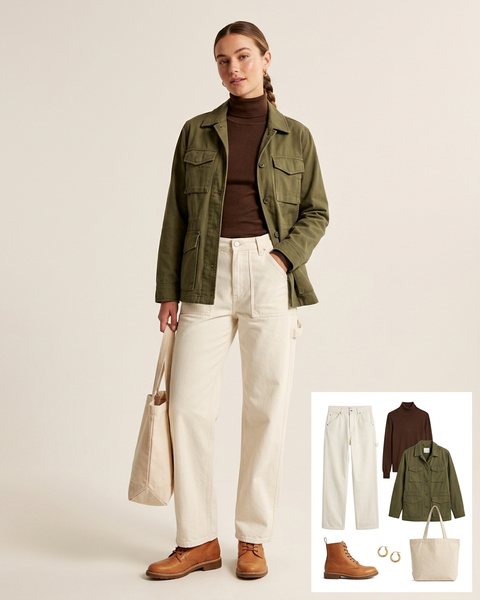Woman wearing ecru carpenter jeans with a chocolate brown turtleneck, an olive field jacket, tan lace-up boots and a canvas tote bag
