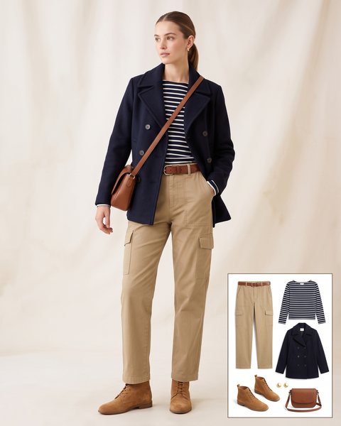 Woman wearing khaki belted cargo pants with a navy striped Breton top, a navy wool peacoat, tan suede lace-up boots and a brown crossbody bag