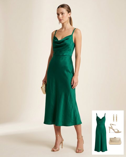 Woman wearing an emerald green satin cowl-neck midi dress with gold strappy heels, a gold clutch and gold chain earrings