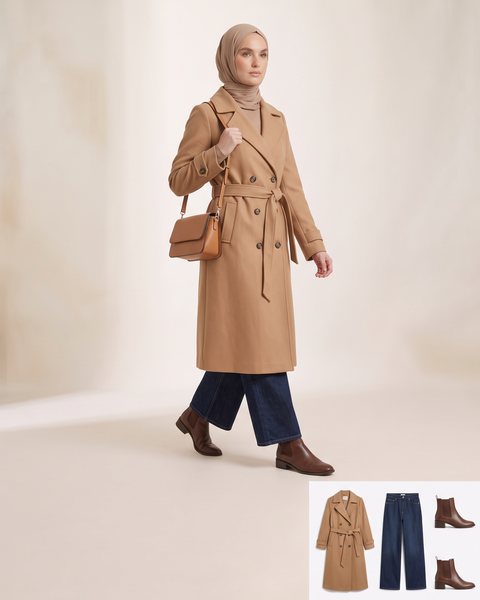 Belted double-breasted trench coat over wide-leg jeans, styled for a cold commute