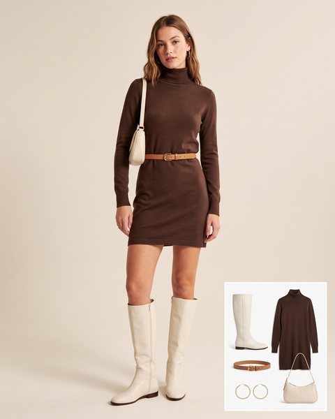 Woman wearing flat ivory knee-high boots with a chocolate brown turtleneck knit mini dress, a tan leather belt and a cream shoulder bag