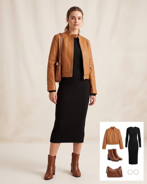 Woman wearing a cropped caramel leather jacket with a black ribbed midi dress, brown block-heel ankle boots and a brown leather shoulder bag