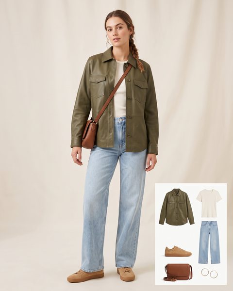 Woman wearing an olive green leather shirt jacket with an ivory tee, light-wash wide-leg jeans, tan suede sneakers and a brown crossbody bag