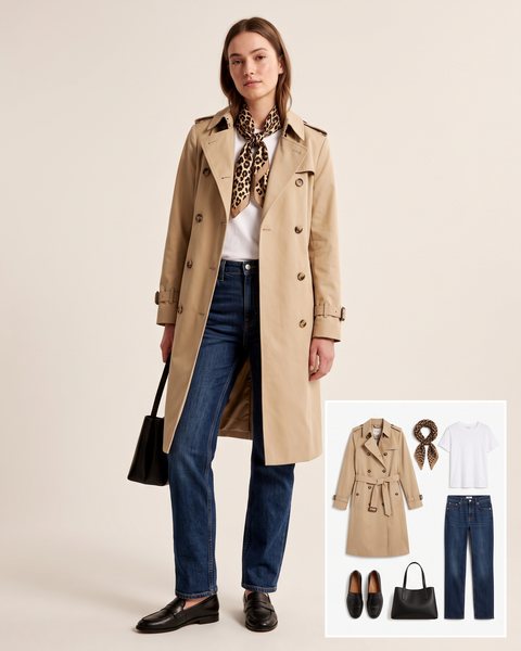 Woman wearing a beige trench coat with a leopard print silk scarf knotted at the neck, a white tee, dark-wash straight-leg jeans, black leather loafers and a black structured handbag