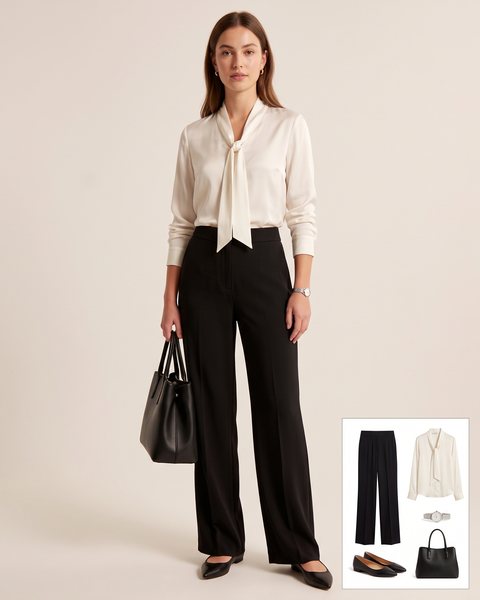 Ivory silk blouse with a soft tie neck tucked into black high-waisted wide-leg trousers, with black flats, a black tote and a silver watch