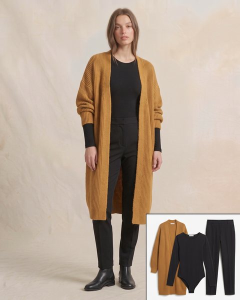 Hardal sarısı uzun oversize örgü hırka, siyah body ve siyah kumaş pantolon ile hazırlanmış ofis oversize kombini